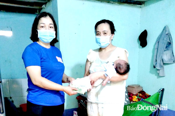 Bà Quách Thị Toan, Chủ tịch Ủy ban MTTQ xã Hàng Gòn tặng quà cho người dân khó khăn do dịch bệnh trên địa bàn xã. Ảnh: NVCC
