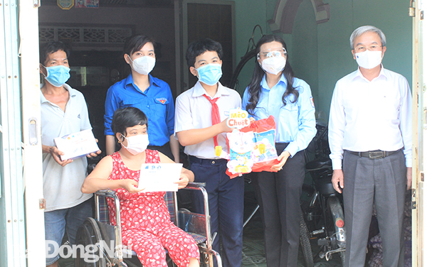Các đại biểu tặng quà, học bổng và thiết bị học trực tuyến cho em Nguyễn Minh Luân, ở ấp Trầu, xã Phước Thiền (H.Nhơn Trạch)