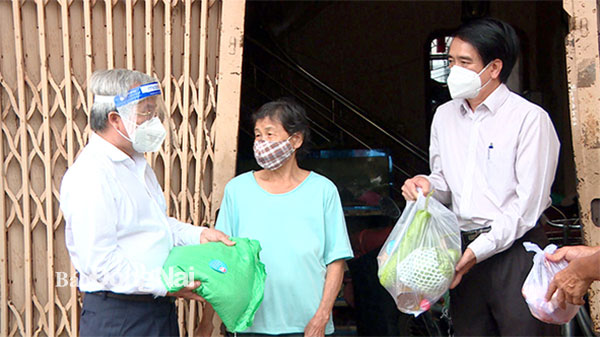 Chủ tịch Ủy ban MTTQ Việt Nam tỉnh Cao Văn Quang (bìa trái) đến tận nhà trao quà cho người dân khó khăn ở P.Tân Biên, TP.Biên Hòa. Ảnh: Nguyệt Hà