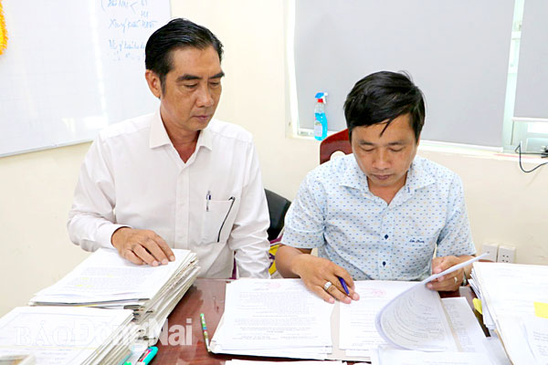 Thành viên Tổ bồi thường xử lý hồ sơ bồi thường, hỗ trợ của một hộ dân thuộc dự án Sân bay Long Thành (ảnh chụp tháng 5-2021)