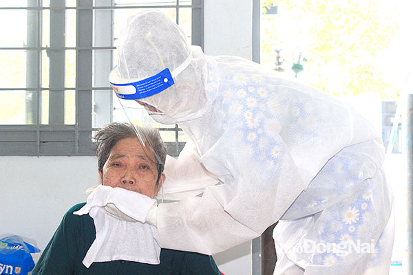 3. Một bệnh nhân Covid-19 lớn tuổi, đang phải thở oxy tại Phòng Cấp cứu của bệnh viện được tình nguyện viên giúp vệ sinh cá nhân