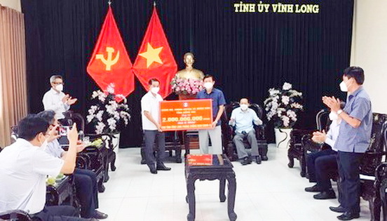 Ông Thái Bảo- Chủ tịch HĐND tỉnh Đồng Nai trao bảng tượng trưng số tiền ủng hộ 2 tỷ đồng cho tỉnh Vĩnh Long phòng chống dịch COVID-19