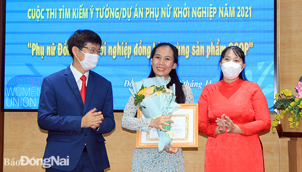 Bà Lê Thị Thái (bìa phải) và TS.Nguyễn Văn Tân (bìa trái) tặng hoa và cúp lưu niệm cho thí sinh đoạt giải nhất cuộc thi 