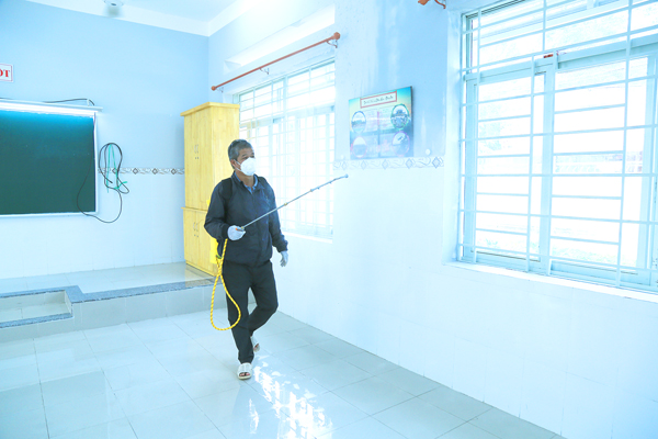 Phụ huynh Nguyễn Văn Long hỗ trợ Ban giám hiệu Trường tiểu học Hiệp Hòa phun khử khuẩn trường lớp 6-7. Giáo viên làm vệ sinh từng cánh cửa lớp học