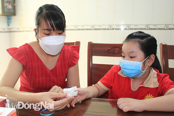 Phụ huynh chăm sóc trẻ mắc Covid-19 tại nhà trên địa bàn TP.Biên Hòa.
