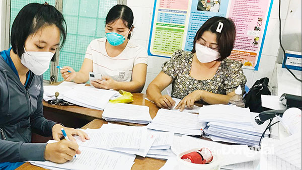 Nhân viên Trạm Y tế P.Trảng Dài (TP.Biên Hòa) làm ngày, làm đêm để hoàn tất hồ sơ cho các F0, F1 hưởng chế độ bảo hiểm xã hội. Ảnh: Phương Liễu