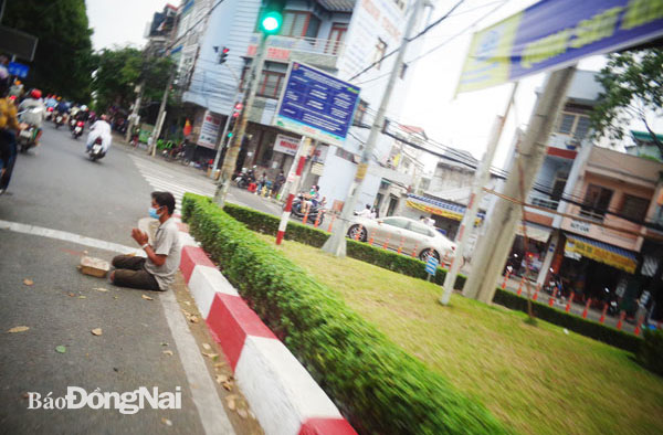 Một người đàn ông ngồi dưới lòng đường Nguyễn Ái Quốc (P.Quang Vinh, TP.Biên Hòa) để xin tiền