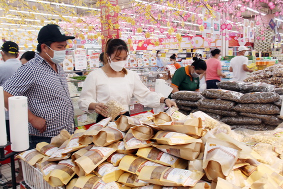 Nhu cầu tiêu thụ các sản phẩm Tết tại các siêu thị tăng cao trong những ngày vừa qua. Trong ảnh: Các sản phẩm hạt dưa, hạt bí, hạt hướng dương… đóng gói sẵn khá “hút hàng”