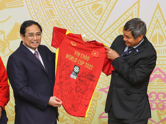 Huấn luyện viên trưởng Đội tuyển Bóng đá nữ Việt Nam Mai Đức Chung trao tặng Thủ tướng áo có chữ ký và quả bóng thi đấu của các thành viên Đội tuyển bóng đá nữ - Ảnh: VGP/Nhật Bắc