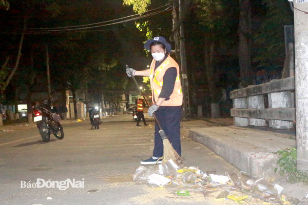 Bà Phan Thị Diễm, công nhân vệ sinh Công ty CP Môi trường Sonadezi cần mẫn quét dọn đường phố mỗi ngày. Ảnh: Tố Tâm