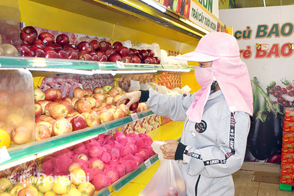 Người tiêu dùng chọn mua trái cây nhập khẩu tại một cửa hàng tiện lợi ở TP.Biên Hòa