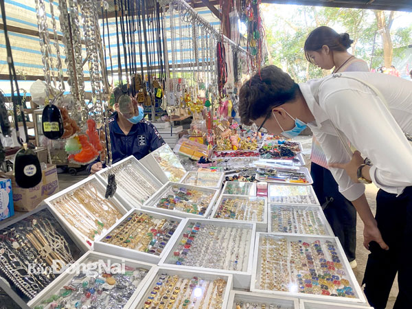 Khu du lịch núi Chứa Chan là một trong những điểm đến bán nhiều mặt hàng lưu niệm hai bên đường lên núi. Trong ảnh: Khách mua sản phẩm lưu niệm tại Khu du lịch núi Chứa Chan