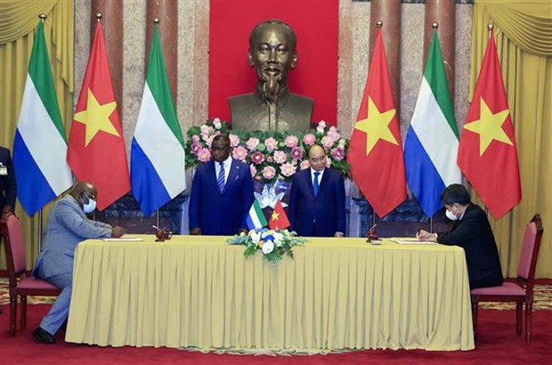 President Nguyen Xuan Phuc (right) and Sierra Leonean President Julius Maada Bio witness the signing of a cooperation agreement between the two countries in agriculture.