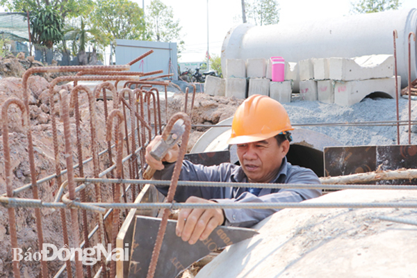 Kết quả giải ngân nguồn vốn đầu tư công trên địa bàn tỉnh đến hết tháng 2-2022 đạt thấp so với mức bình quân chung của cả nước. Trong ảnh: Công nhân thi công dự án Đường D9, TP.Biên Hòa