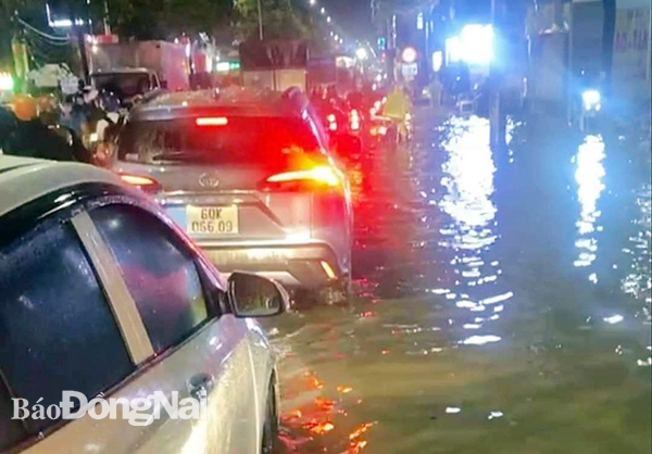 Nước ngập sâu khiến các phương tiện di chuyển khó khăn trên đường Nguyễn Ái Quốc (đoạn qua P.Tân Phong). Ảnh:CTV