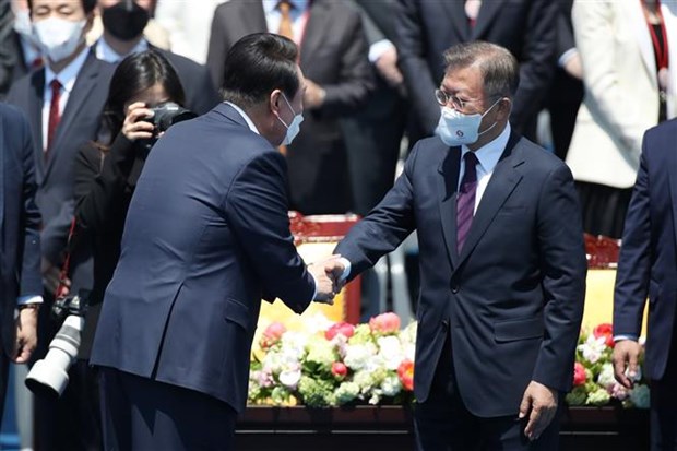Tân Tổng thống Hàn Quốc Yoon Suk-yeol (trái) bắt tay người tiền nhiệm Moon Jae-in trong lễ nhậm chức ngày 10-5-2022. Ảnh: TTXVN