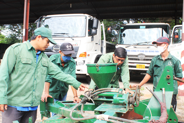 Anh Nguyễn Hồ Tấn (bìa trái), Tổ trưởng Tổ vận tải, Nông trường Cao su Long Thành đang giới thiệu về dàn máy 4 trong 1. Ảnh: N.Sơn
