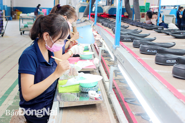 Càng phát triển sản xuất công nghiệp, càng phải quan tâm công tác bảo vệ môi trường. Trong ảnh: Sản xuất giày thể thao tại Công ty TNHH Changshin Việt Nam (H.Vĩnh Cửu)