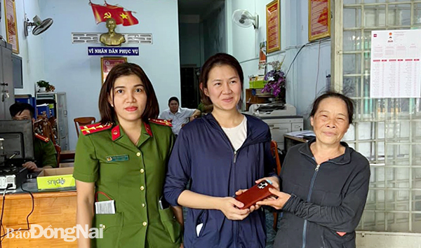 Bà Trần Thị Hoa (bìa phải) trao trả chiếc điện thoại cho người đánh mất (Ảnh: CTV)