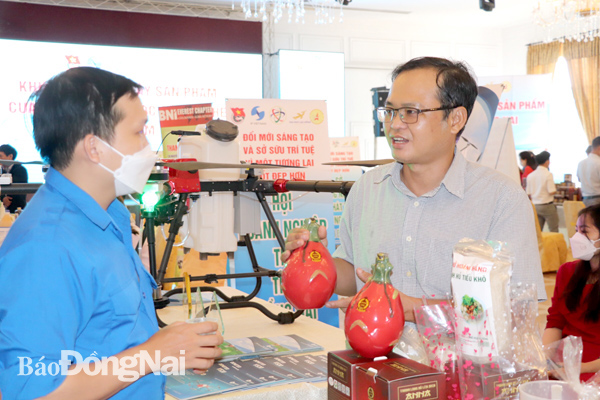Ông Ngô Thanh Long, chủ doanh nghiệp sản xuất nước thanh long lên men Anna (H.Thống Nhất, phải) đưa sản phẩm lên sàn thương mại điện tử Shopee