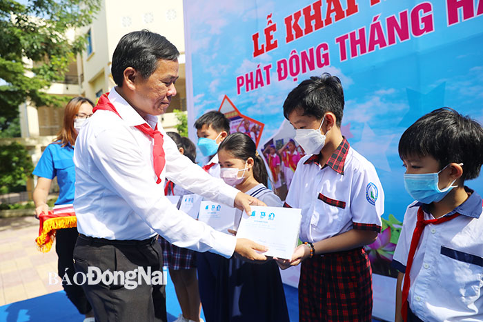 Ông Đinh Kim Tuấn, Phó tổng biên tập báo Đồng Nai, thành viên Ban chỉ đạo hè tỉnh trao học bổng cho các em học sinh có hoàn cảnh khó khăn.