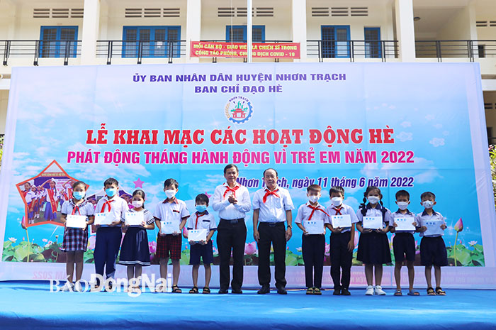 Phó tổng biên tập báo Đồng Nai Đinh Kim Tuấn và Phó chủ tịch UBND H.Nhơn Trạch Lương Văn Ích trao học bổng cho các em học sinh có hoàn cảnh khó khăn.