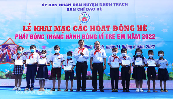 Phó tổng biên tập báo Đồng Nai Đinh Kim Tuấn và Phó chủ tịch UBND H.Nhơn Trạch Lương Văn Ích trao học bổng cho các em học sinh có hoàn cảnh khó khăn. Ảnh: Huy Anh