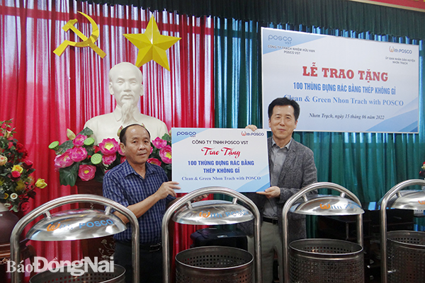 Phó chủ tịch UBND huyện Nhơn Trạch Lương Hữu Ích tiếp nhận biểu trưng trao tặng 100 thùng rác từ Tổng giám đốc Công ty POSCO VST   