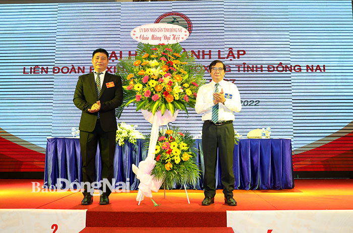 Phó chủ tịch UBND tỉnh Nguyễn Sơn Hùng (phải) tặng lẵng hoa chúc mừng đại hội Liên đoàn Boxing - Kickboxing Đồng Nai
