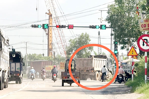 Xe tải vượt đèn đỏ rẽ phải từ quốc lộ 51 vào đường chuyên dùng đến mỏ đá Tân Cang (P.Phước Tân, TP.Biên Hòa) trong khi các xe máy đang chạy thẳng theo đèn xanh trên quốc lộ 51, việc này dễ xảy ra tai nạn giao thông. Hình chụp sáng 6-6. Ảnh: Đông Hồ