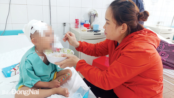 Chị Lê Thị Trang (ngụ P.Xuân Hòa, TP.Long Khánh) chăm sóc con tại Bệnh viện Nhi đồng Đồng Nai sau ca phẫu thuật