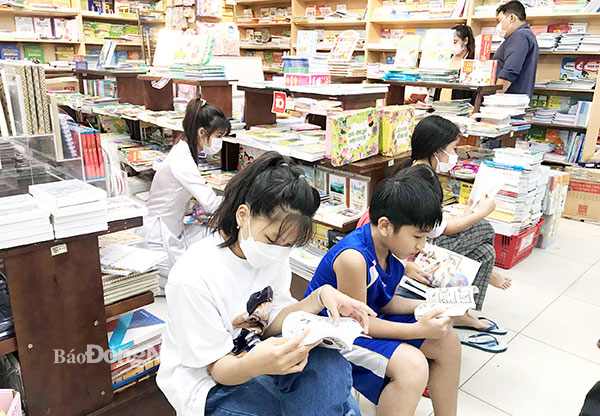 Nhiều trẻ say sưa đọc truyện, sách khi được phụ huynh đưa đi nhà sách (Ảnh chụp tại Nhà sách Fahasha, Trung tâm Thương mại BigC Tân Hiệp). Ảnh: Hải Yến