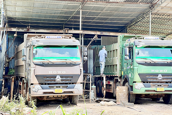 Những chiếc xe cơi nới thùng xếp hàng trên tuyến đường chuyên dùng vào mỏ đá Tân Cang để tháo dỡ phần cơi nới sai quy định