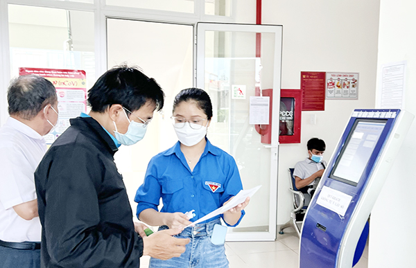 Đoàn viên tại Trung tâm Hành chính công tỉnh hướng dẫn cho người dân đến giải quyết thủ tục hành chính. Ảnh: Công Nghĩa