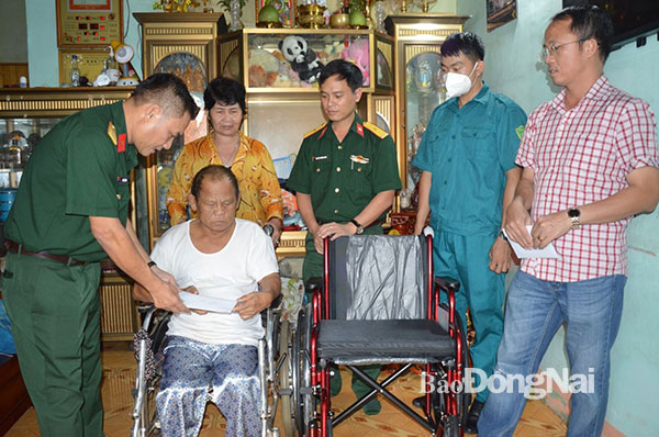 Thượng tá Bùi Tấn Mẫn ngoài cùng (bìa trái) cùng đoàn công tác tặng quà, xe lăn cho thượng tá Đặng Văn Minh