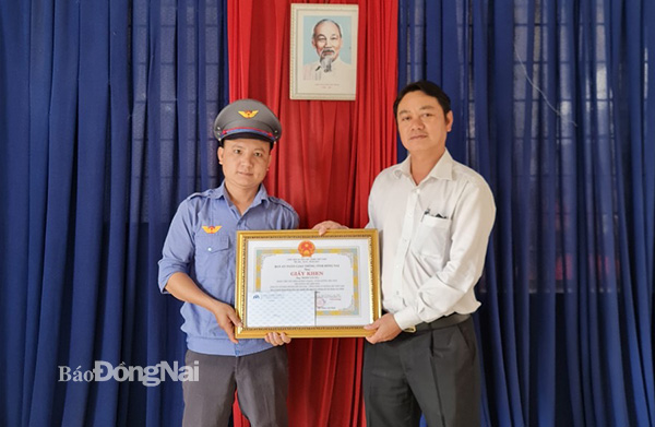 Đại diện Ban An toàn giao thông tỉnh khen thưởng ông Trịnh Văn Tài (nhân viên gác chắn xe lửa tại TP.Long Khánh) dũng cảm cứu người. Ảnh: Đăng Tùng