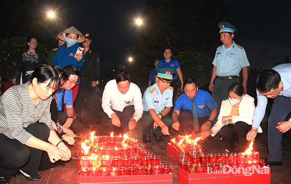 Các đại biểu thắp nến tri ân các anh hùng liệt sĩ. Ảnh: Nga Sơn