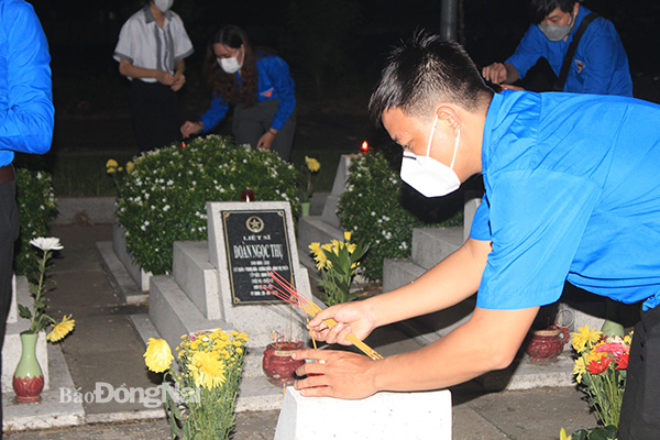 Đoàn viên thanh niên thắp nến tri ân trên các phần mộ liệt sĩ. Ảnh: Nga Sơn