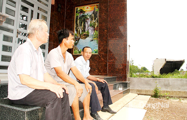 Ngồi ở căn nhà mới, gia đình ông Lâm Văn Lộc (dân tộc Nùng, xã Xuân Phú, H.Xuân Lộc) nhìn về hướng dự án Đường cao tốc Phan Thiết - Dầu Giây đang thực hiện trên phần đất cũ trước đây của gia đình. Ảnh: S.Thao