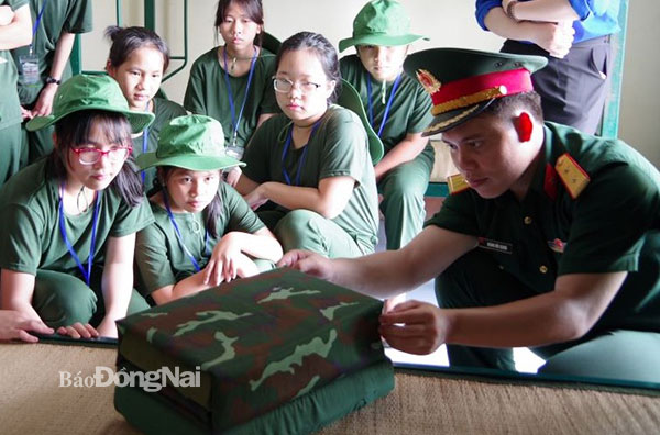 Học viên tham gia chương trình Học kỳ quân đội được cán bộ hướng dẫn gấp nội vụ tại Đoàn C6 (Bộ Quốc phòng). Ảnh: Nguyệt Hà