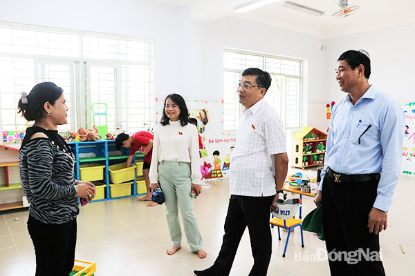 Phó chủ nhiệm Ủy ban Kinh tế của Quốc hội Nguyễn Minh Sơn và Phó chủ tịch UBND tỉnh Võ Văn Phi thăm hỏi giáo viên về hoạt động chuẩn bị cho năm học mới tại một trường mầm non ở Khu tái định cư Lộc An - Bình Sơn. Ảnh: Phạm Tùng