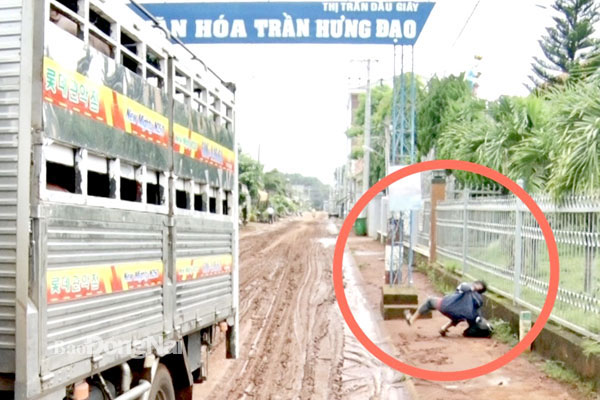 Một người đi bộ bị trượt té trên đoạn đường ngập bùn đất sau cơn mưa ngày 3-8 ngay cổng chào KP.Trần Hưng Đạo (TT.Dầu Giây, H.Thống Nhất). Ảnh: K.Thành