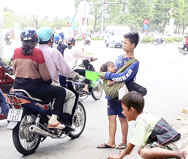 Trẻ em bồng bế nhau ra đường để xin ăn ở khu vực ngã tư Amata (TP.Biên Hòa). Ảnh: P.Liễu