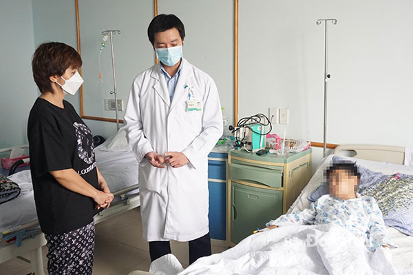 BS Trần Ngọc Lưỡng dặn dò phụ huynh cách chăm sóc bệnh nhi sau ca phẫu thuật. Ảnh: Hạnh Dung