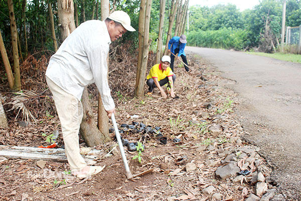 Trưởng ban Công tác Mặt trận ấp Suối Đục Nguyễn Văn Lãnh cùng người dân dọn dẹp vệ sinh, trồng cây xanh trên địa bàn ấp. Ảnh: Đoàn Phú