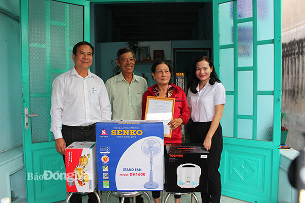 Đại diện Điện lực Nhơn Trạch trao quyết định tặng nhà tình nghĩa cho hộ bà Trương Thị Vân xã Phú Hữu, (H.Nhơn Trạch). Ảnh: H.Lộc