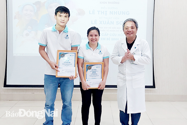 BS Hồ Thanh Phong, Giám đốc chuyên môn Bệnh viện Quốc tế Hoàn Mỹ Đồng Nai tặng giấy khen của bệnh viện cho 2 cá nhân.