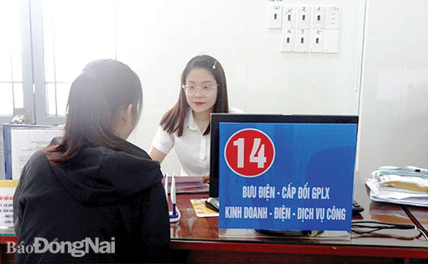 Công chức Bộ phận một cửa UBND H.Nhơn Trạch trực tiếp nhận hồ sơ của người dân và doanh nghiệp. Ảnh: Xuân Mai