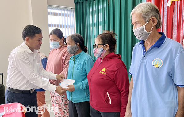 .Phó tổng biên tập Báo Đồng Nai Đinh Kim Tuấn trao tặng thẻ bảo hiểm y tế cho người dân