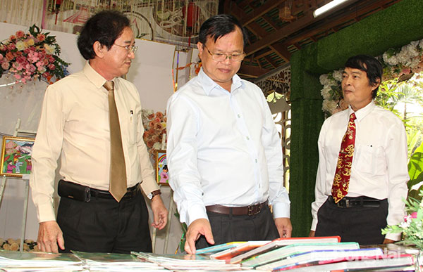 Phó bí thư Tỉnh ủy, Chủ tịch UBND tỉnh Cao Tiến Dũng tham quan tranh và sách trưng bày tại chương trình giao lưu. Ảnh: Sông Thao